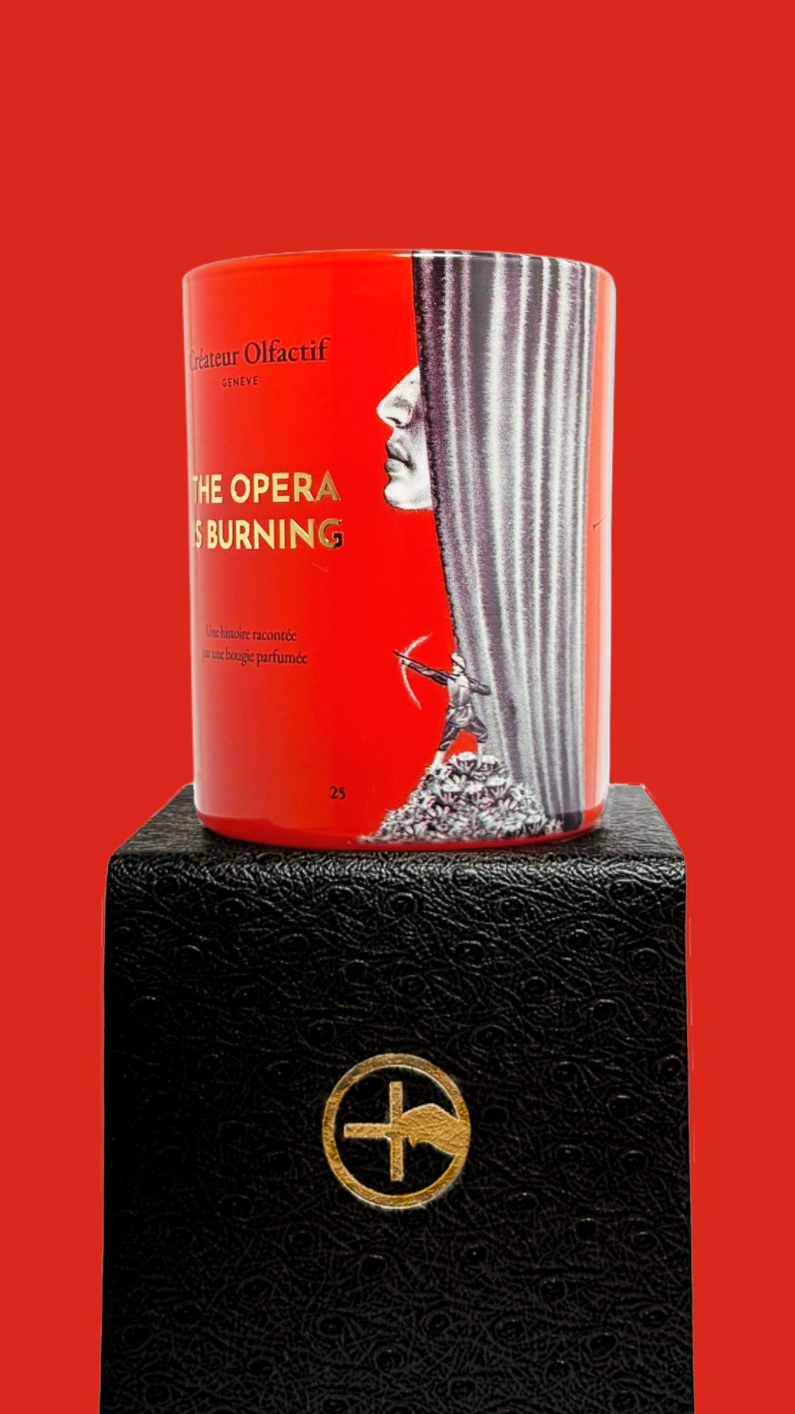 Red scented candle with 'The Opera is Burning' text and proprietary Créateur Olfactif illustrations on a red background