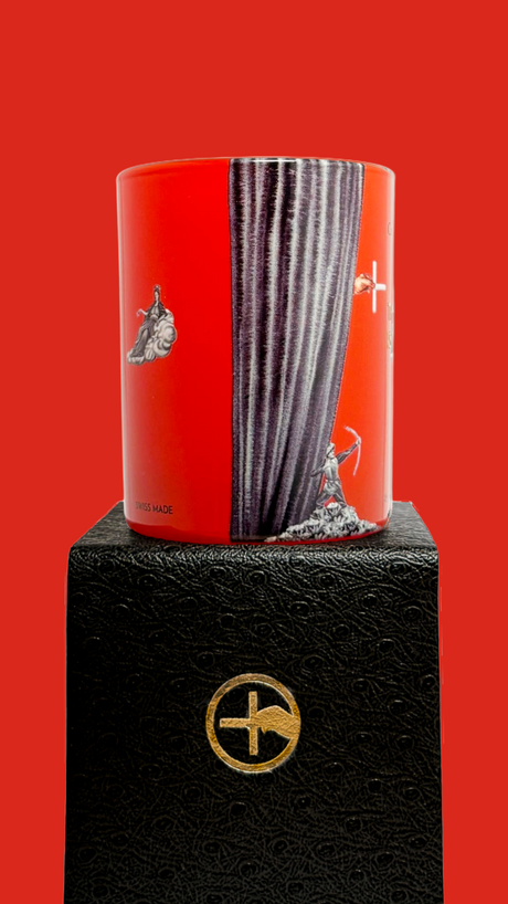 Red scented candle with 'The Opera is Burning' text and proprietary Créateur Olfactif illustrations on a red background
